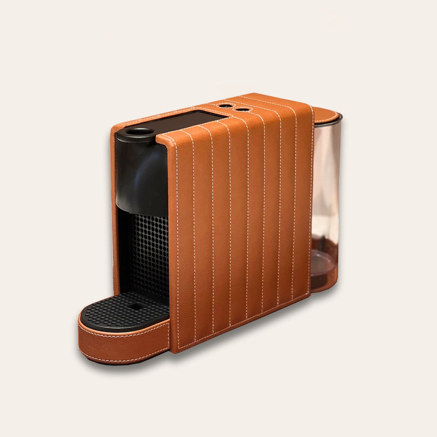 Mini Essenza Nespresso Machine with a vegan leather finish in tan brown with white stitching. Luxury nespresso machines