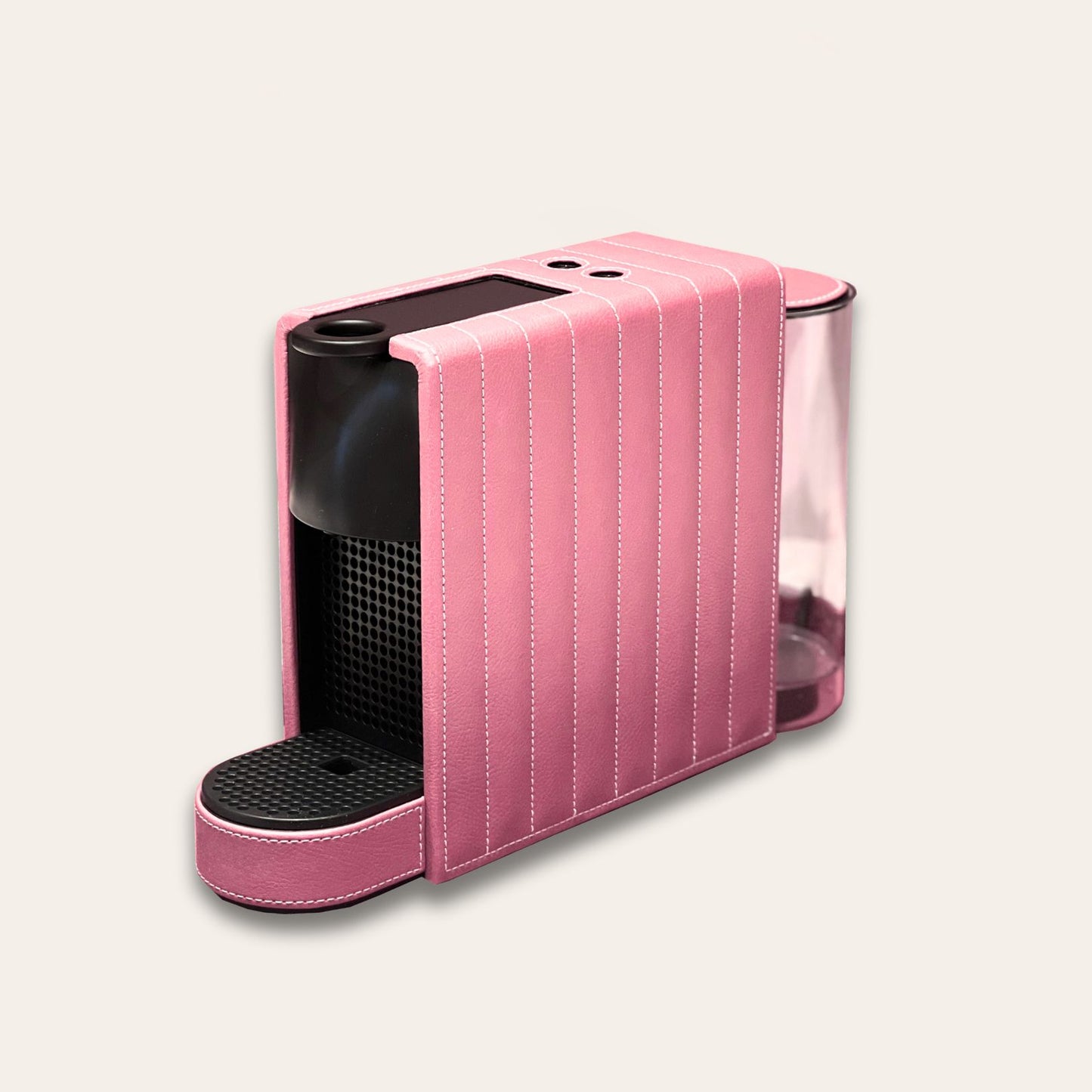 Nespresso Essenza Mini coffee machine featuring a stylish baby pink vegan leather covering, perfect for small spaces.
