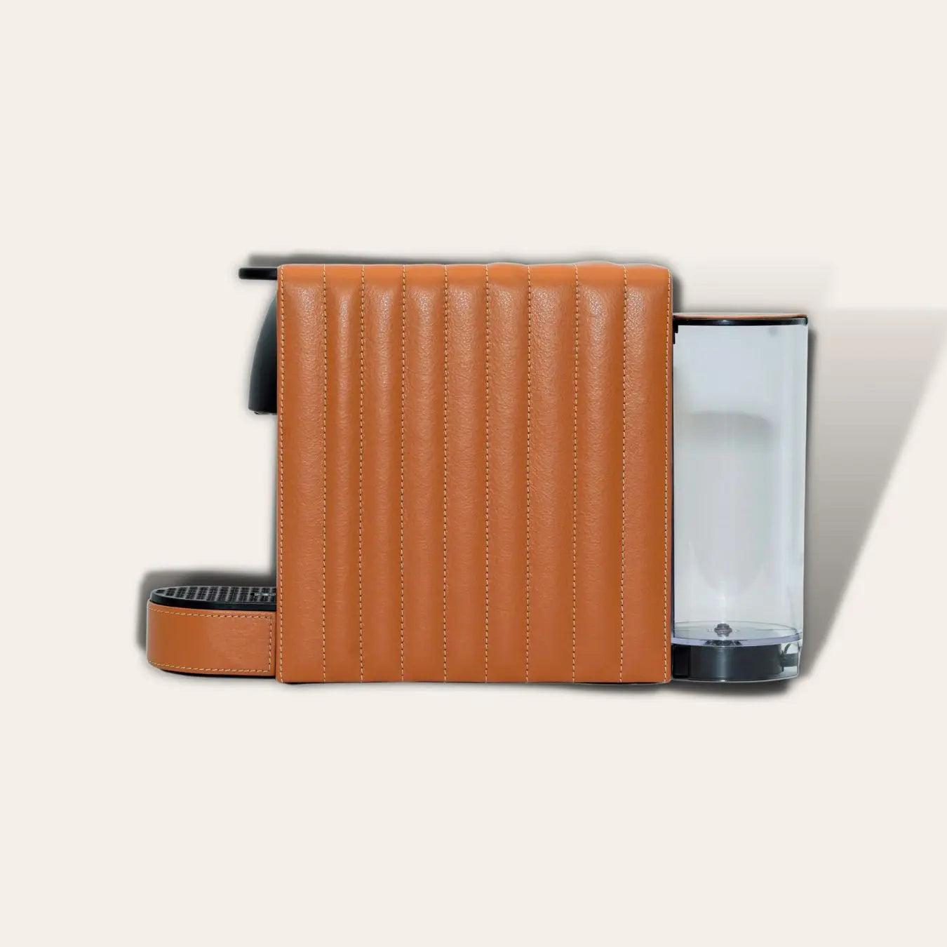 Compact Nespresso Essenza Mini coffee machine with a tan brown vegan leather exterior with vertical line stitiching