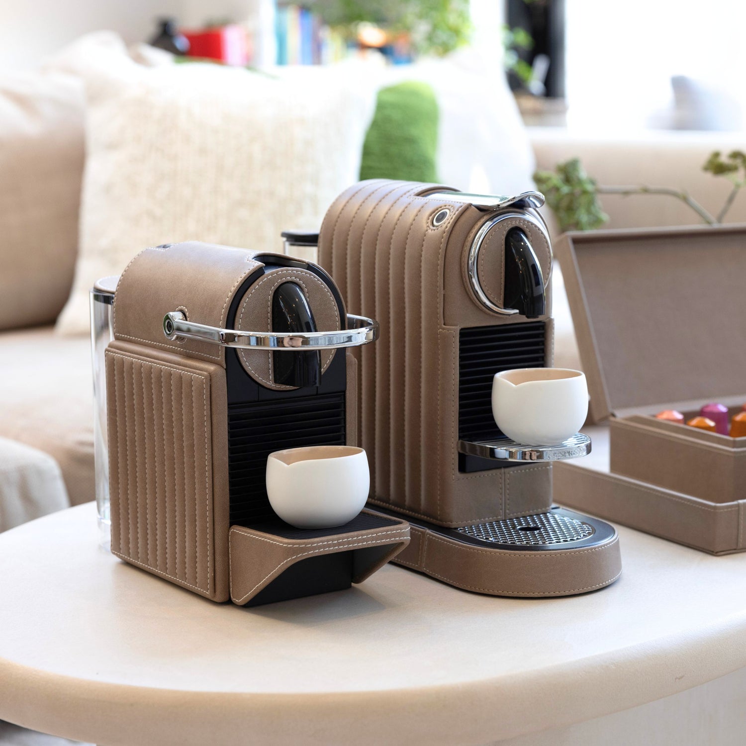 Two nespresso coffee machines covered in a taupe brown vegan leather in a lounge area