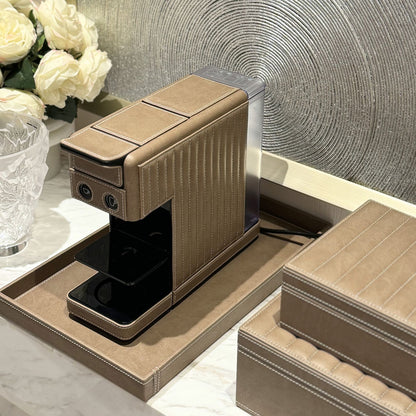 Illy compact coffee capsule machine cladded in a taupe vegan leather made in the UAE. Paired with a tray and storage boxes