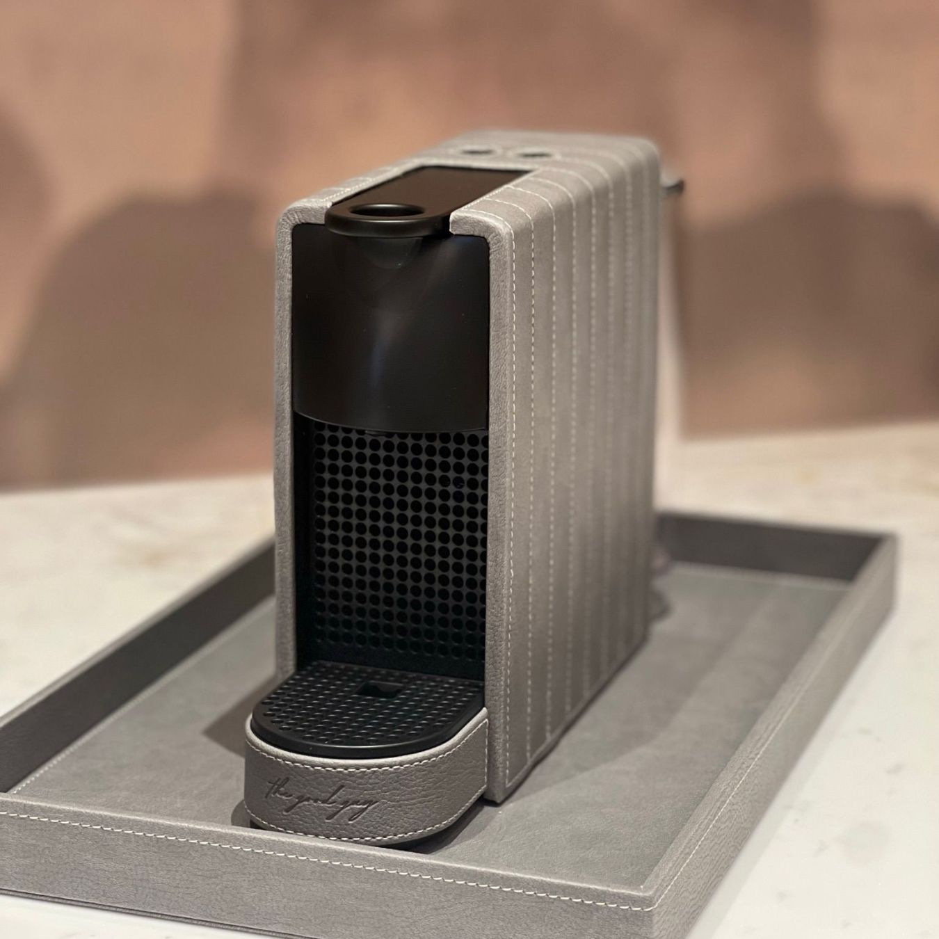 Nespresso Essenza Mini coffee machine featuring a stylish silver grey vegan leather covering, perfect for small spaces.