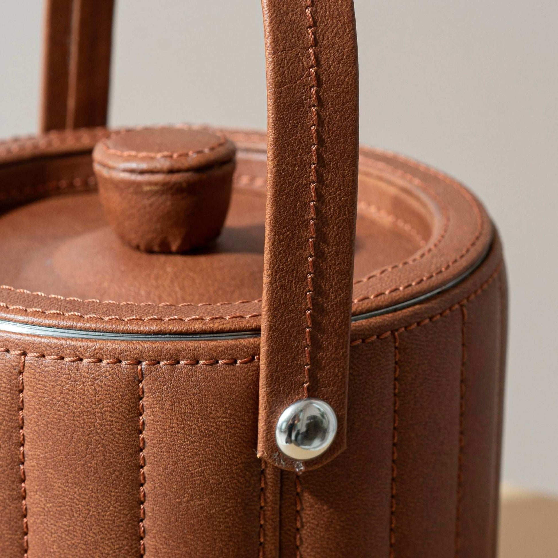 close up details of the leather cladded ice bucket in tan brown with stitching