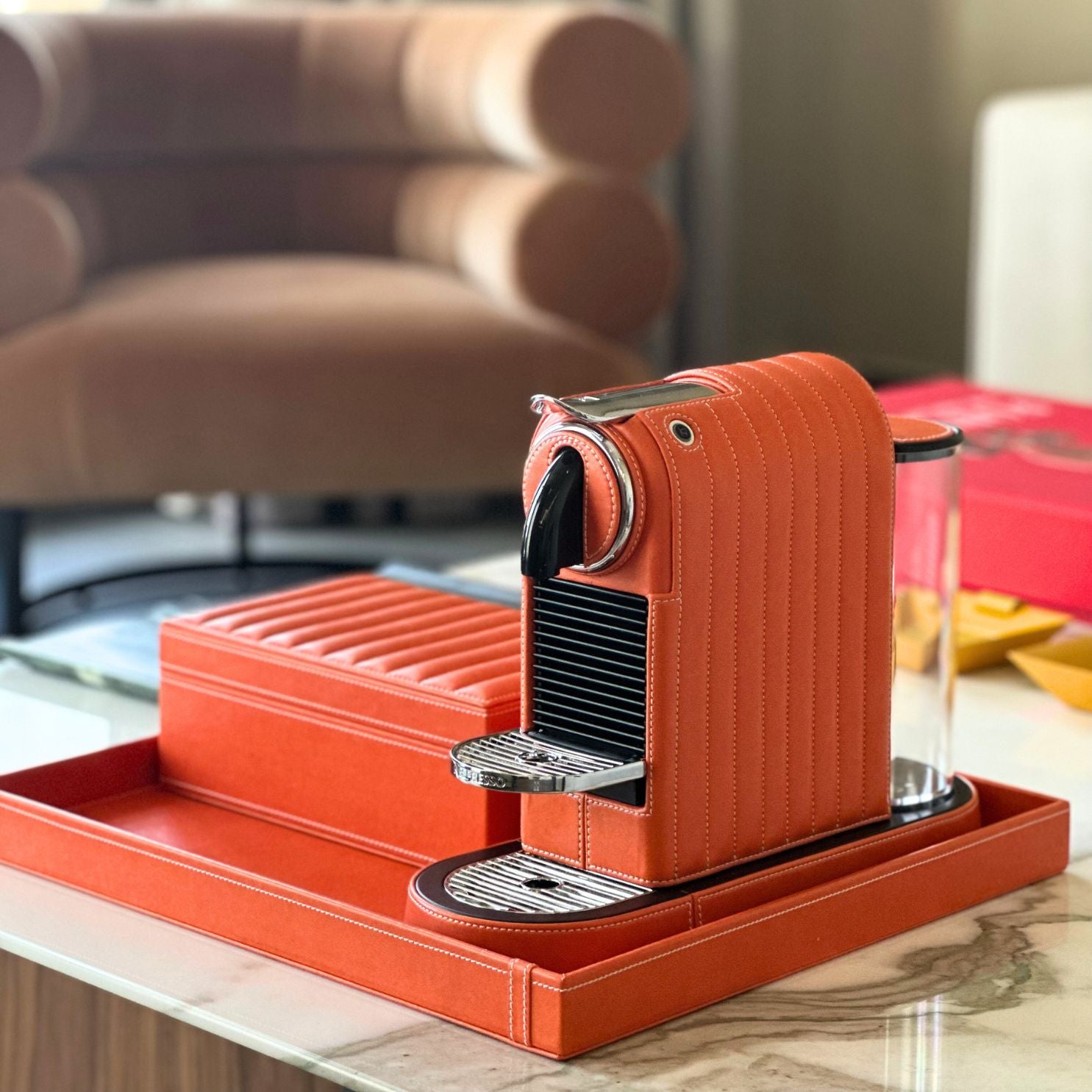 Nespresso Citiz Coffee Machine cladded with an orange colored vegan leather with a storage box for cups, spoons or capsules all kept together with a leather covered tray for serving