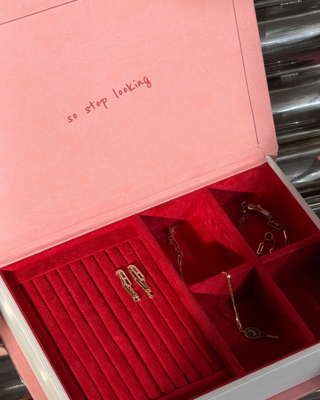 Pink leatherette jewelry box with red velvet interior compartments