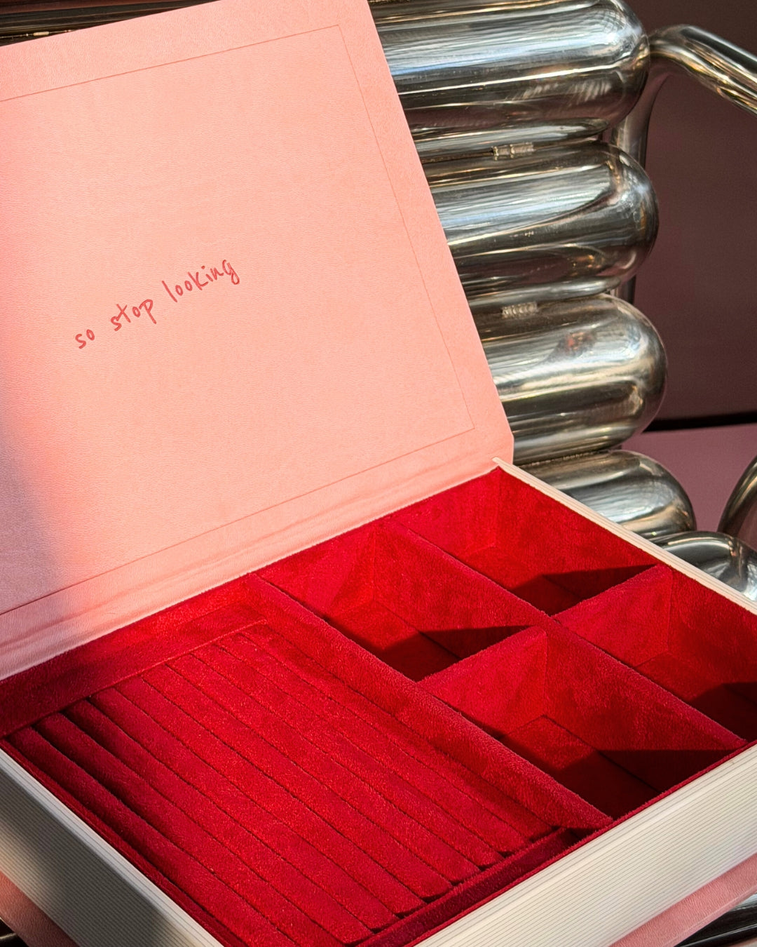 Pink leatherette jewelry box with red velvet interior compartments