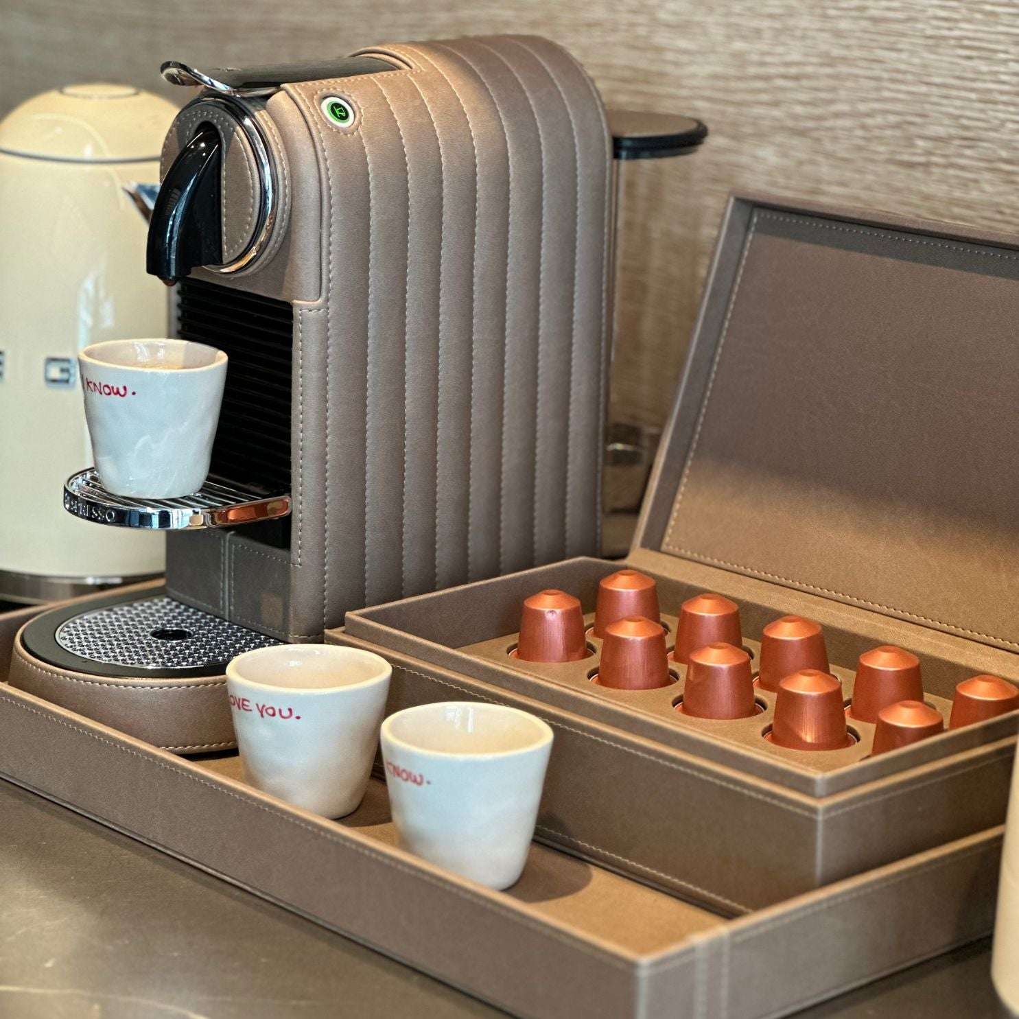Nespresso Citiz Coffee Machine covered in a taupe colored vegan leather with a capsule box